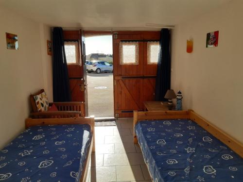 - une chambre avec 2 lits et une porte menant à une allée dans l'établissement Port Leucate: Villa 6 pers. face à la mer, cosy, proche activités - FR-1-798-40, à Leucate