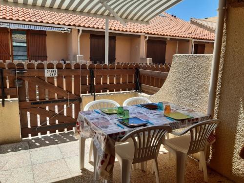 une table et des chaises assises sur une terrasse dans l'établissement Villa Climatisée avec Mezzanine, Parking Sécurisé et Terrasse près du Lac Marin pour 4 Personnes - FR-1-798-42, à Leucate