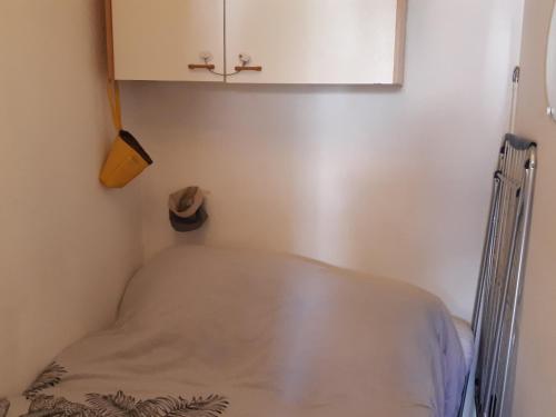 un lit dans un coin d'une pièce avec une armoire dans l'établissement Villa Studio Climatisée 2/3 Pers. Port Leucate, Parking Sécurisé - FR-1-798-45, à Leucate