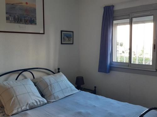 une chambre avec un lit avec des draps blancs et une fenêtre dans l'établissement T2 Front de Mer, Rez-de-Chaussée, Port Leucate, Parking, 5 Personnes - FR-1-798-6, à Leucate