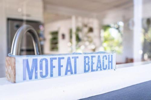 a metal sign on a kitchen counter with a sink at Wara Wara on Moffat Beach Foreshore in Caloundra