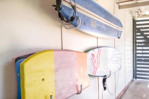 two surfboards and a mirror hanging on a wall at Wara Wara on Moffat Beach Foreshore in Caloundra