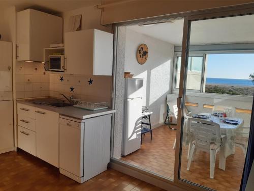 une petite cuisine avec une table et une fenêtre dans l'établissement Studio cabine à Port Leucate, 4 pers, animaux admis, parking, accès direct à la mer - FR-1-798-19, à Leucate