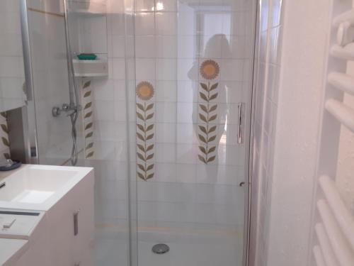 une salle de bain avec une douche avec des autocollants de tournesol dessus dans l'établissement Charmante Villa T3 Mezzanine Climatisée avec Piscine et Parking Privé - 6 Pers., Port Leucate - FR-1-798-41, à Leucate