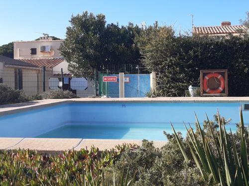 une grande piscine bleue dans une cour dans l'établissement Charmante Villa T3 Mezzanine Climatisée avec Piscine et Parking Privé - 6 Pers., Port Leucate - FR-1-798-41, à Leucate