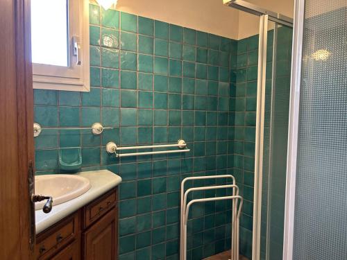 La salle de bains est pourvue de carrelage vert, d'un lavabo et d'une douche. dans l'établissement Villa calme avec piscine privée, parking, 3 chambres, pour 6 à Bormes-les-Mimosas - FR-1-251-837, à Bormes-les-Mimosas