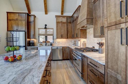 a large kitchen with wooden cabinets and stainless steel appliances at BHA - Luxury A-Frame in Creede