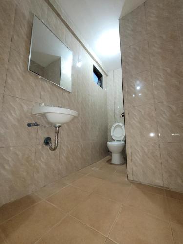 a bathroom with a sink and a toilet at J&V Oceanview Beach Resort in Lalauigan