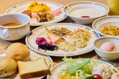 a table with plates of food and bowls of food at Hotel Kumamoto Terrsa in Kumamoto