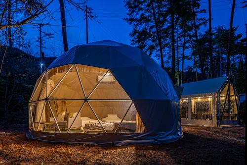 a blue dome tent in front of a building at glampark Hinokiyunoyado Nagano in Azumino
