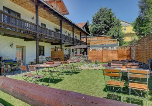 a patio with tables and chairs in a yard at Ferienhof Landhaus Guglhupf in Sankt Oswald