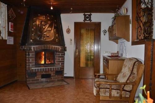 a living room with a brick fireplace and a chair at Almhaus am Hohenwart in Klippitztörl in Klippitztorl