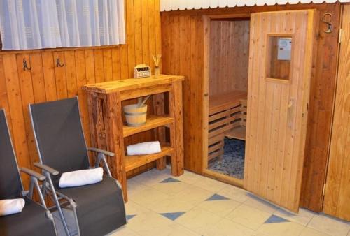 a room with a horse stall with a door and chairs at Almhaus am Hohenwart in Klippitztörl in Klippitztorl