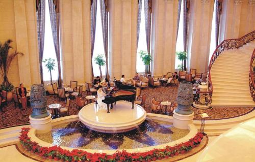 a woman playing a grand piano in a hotel lobby at Sanya Baohong Hotel in Sanya