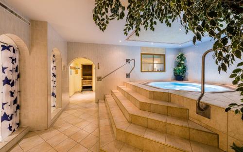 eine Whirlpool-Badewanne in einem Zimmer mit Treppe in der Unterkunft Hotel Forer in Ladis