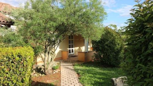 een huis met een boom en een loopbrug bij Bungalow mit Pool und Garten in Porec in Poreč