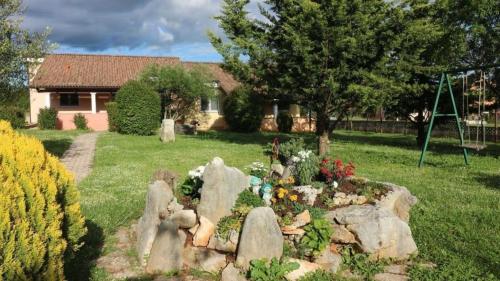 een tuin voor een huis met rotsen en bloemen bij Bungalow mit Pool und Garten in Porec in Poreč