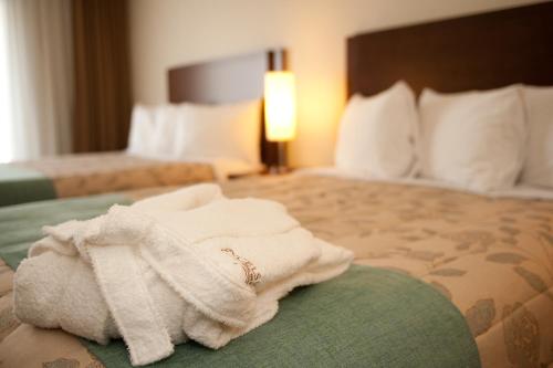 a hotel room with a pile of towels on a bed at Excelsior Hôtel Spa Sainte-Adèle in Sainte-Adèle