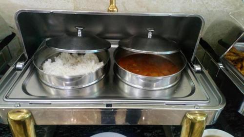 two pots of food sitting on top of a stove at Bacninh Charming Hotel in Bắc Ninh