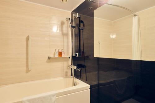 a bathroom with a shower and a bath tub at Hotel Kumamoto Terrsa in Kumamoto