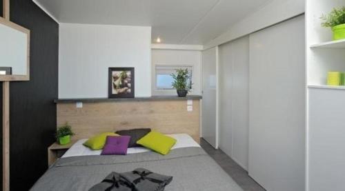 a bedroom with a bed with yellow and purple pillows at Nettes Ferienhaus in Wackersdorf mit Sauna, Grill und Whirlpool in Wackersdorf