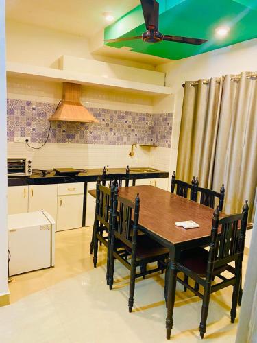 a kitchen with a table with chairs and a ceiling fan at Vyana villa by the beach in Morjim