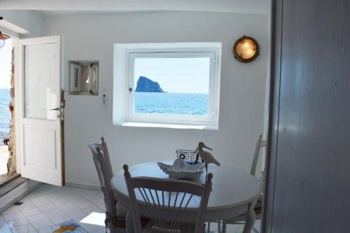 d'une salle à manger avec une table et une fenêtre. dans l'établissement Villa Il Galeone, à Panarea