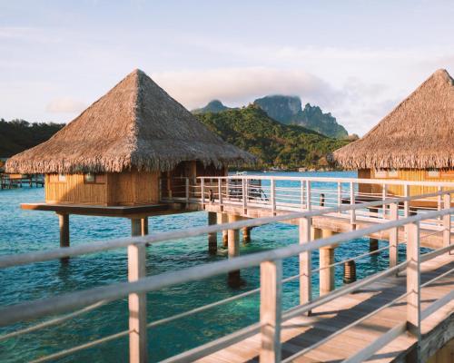 a resort on the water with thatched huts at InterContinental Bora Bora Le Moana Resort by IHG in Bora Bora