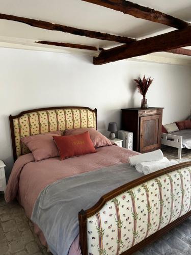 une chambre avec un grand lit avec une tête de lit en bois dans l'établissement Sous la glycine, à Sarrazac