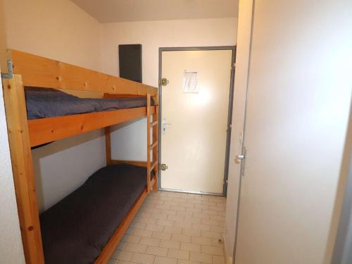 Cette petite chambre comprend 2 lits superposés et une porte. dans l'établissement Studio Cabine avec Piscine à 500m de la Plage au Grau-du-Roi - FR-1-307-268, à Cabrerolles