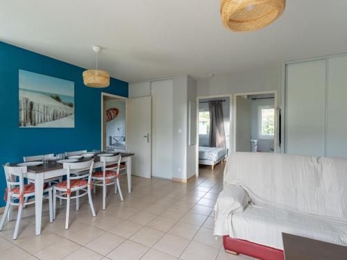 un salon et une salle à manger avec une table et des chaises dans l'établissement Maison avec Piscine à Parentis-en-Born, près du Lac – 3 Chambres, Terrasse et WiFi Inclus - FR-1-319-572, à Parentis-en-Born