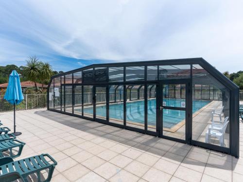 une maison en verre avec une piscine. dans l'établissement Maison avec Piscine à Parentis-en-Born, près du Lac – 3 Chambres, Terrasse et WiFi Inclus - FR-1-319-572, à Parentis-en-Born