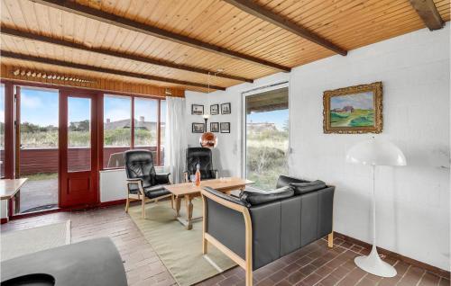 a living room with a table and chairs at 3 Bedroom Lovely Home In Blåvand in Blåvand
