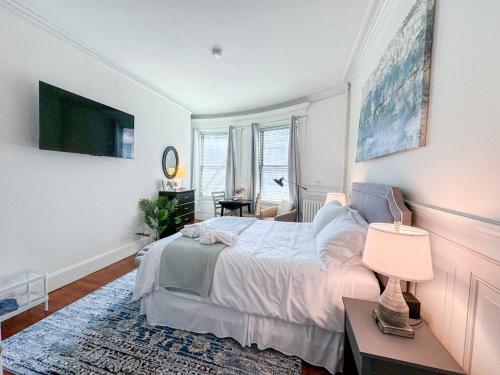 a bedroom with a bed and a table with a lamp at Pvt Room, St Marys, Fenway, Longwood, Green Line in Brookline