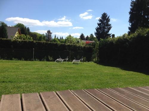 two chairs sitting in the grass in a yard at Haus Waldesrauschen der Ferienanlage Rabenstein in Chemnitz