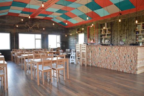 a restaurant with wooden tables and chairs and a bar at Guesthouse Holmur in Hólmur