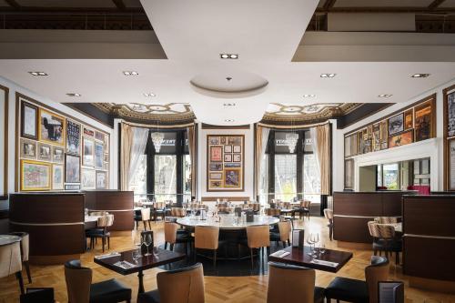 a restaurant with tables and chairs and paintings on the walls at Hotel Indigo - Edinburgh - Princes Street by IHG in Edinburgh