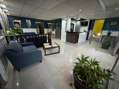 a lobby with a blue couch and some plants at Hotel Santa Cruz in Chihuahua
