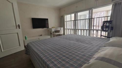 a bedroom with a bed and a flat screen tv at Chaoyang Joy City Hardcover Apartment in Beijing
