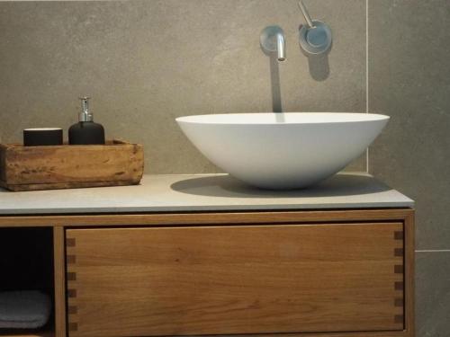 a white bowl on top of a cabinet with a sink at Exklusives Ferienhaus in Huppenbroich mit Terrasse, Grill und Garten in Simmerath