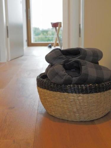 a basket sitting on a wooden floor next to a door at Exklusives Ferienhaus in Huppenbroich mit Terrasse, Grill und Garten in Simmerath