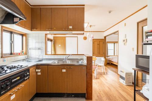 a kitchen with wooden cabinets and a sink at Popotel 2 NIKAI in Matsumoto