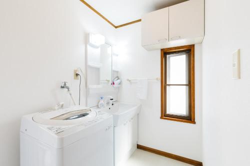 a white bathroom with a sink and a mirror at Popotel 2 NIKAI in Matsumoto
