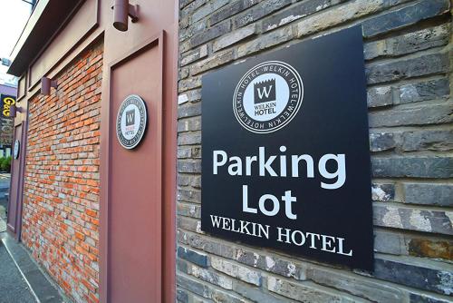 a parking lot sign on a brick building at Welkin Hotel in Busan