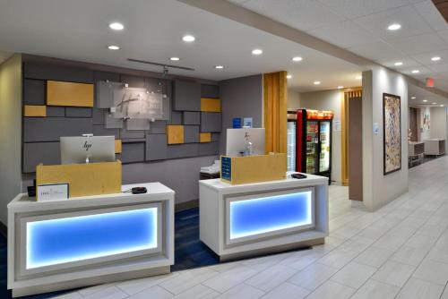 a lobby of a store with two counters with blue screens at Holiday Inn Express & Suites - Wylie West by IHG in Wylie