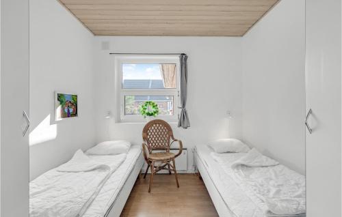 a room with two beds and a chair in it at Holiday Home Lyngvejen Rømø V in Rømø Kirkeby
