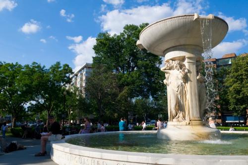 a fountain in a park with people sitting around it at Vignette Collection Yours Truly DC by IHG in Washington