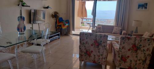 a living room with a glass table and chairs at Sea View Apartment at Tala Bay Resort in Aqaba in Aqaba