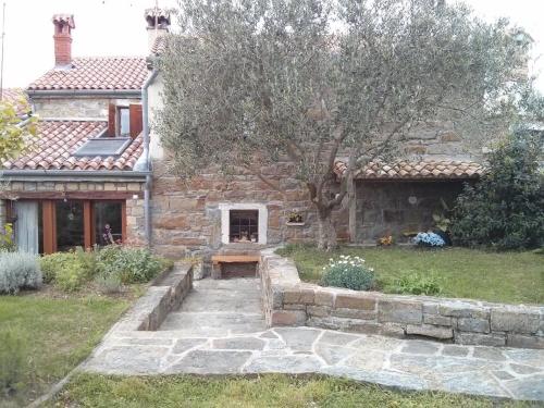 a stone house with a bench in the yard at Ferienhaus für 4 Personen ca 100 qm in Nova Vas nad Dragonjo, Küstenland Slowenien in Nova Vas nad Dragonjo
