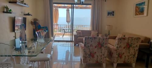 a living room with a glass table and chairs at Sea View Apartment at Tala Bay Resort in Aqaba in Aqaba